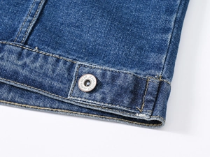 Détails de l'ourlet de la veste en jean bleu foncé avec coutures orange et bouton métal