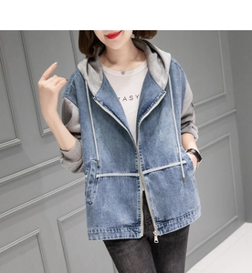 Détail de la veste en jean à manches en maille grise et fermeture éclair métallique