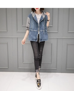 Détail d'une veste en jean à capuche avec manches en tricot gris et fermeture éclair