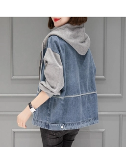 Détail de la veste en jean à capuche avec manches en maille grise et ourlet côtelé