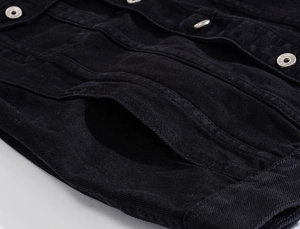 Detailed macro view of black denim jacket silver metal buttons and reinforced stitching