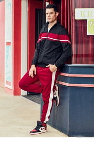 Men's casual tracksuit featuring a black zip-up jacket and red drawstring pants
