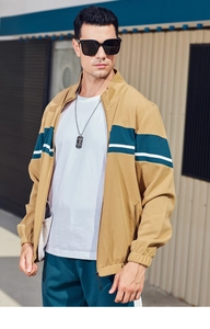 Detail of waffle textured beige tracksuit jacket with green and white color blocking