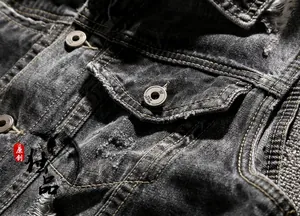 Detail of grey distressed denim vest featuring flap pocket and engraved metal buttons