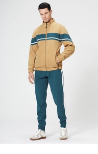 Detail of men's color-block tracksuit with ginger yellow jacket and dark green pants