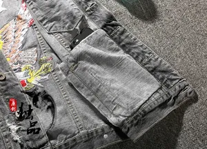 Detail of grey denim vest showing embroidered eagle with floral patterns and inner pocket
