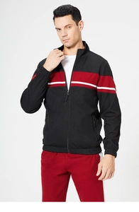 Close-up of black jacket with red stripes and white piping on athletic tracksuit