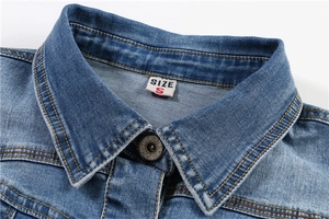 Macro detail of mid-blue denim vest collar with metal button and size S tag