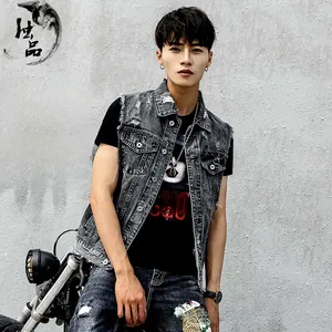 Detail of distressed grey denim vest with vintage ripped effects and frayed armholes