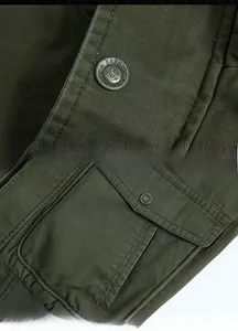 Détail d'une veste militaire vert armée avec bouton en métal et poche cargo renforcée