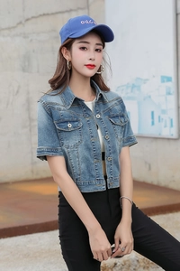 Detail of short sleeve denim jacket with silver buttons and flap pockets in light blue