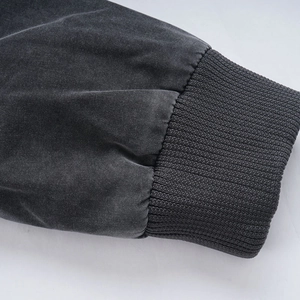 Detail of dark gray washed cotton jacket featuring elastic ribbed knit cuffs and vintage texture