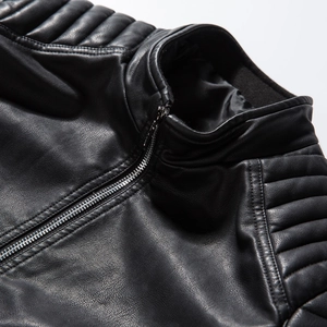 Macro detail of black PU leather jacket featuring stand collar and quilted shoulder seams