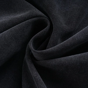 Macro shot of pure black cotton jacket fabric showing soft texture and velvet finish