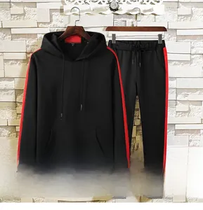 Détail de la manche d'un survêtement noir avec rayures rouges et broderies
