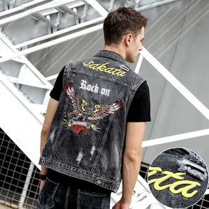 Close-up of eagle embroidery and gothic lettering on grey distressed denim vest