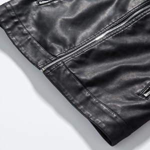 Detailed macro view of black PU leather jacket featuring a smooth metal zipper and fine texture