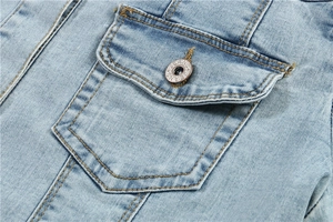 Detail of light blue denim jacket with flap pocket and engraved metal JEANS button