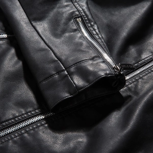 Detail of premium black PU leather texture and shiny silver metal zipper on sleeve