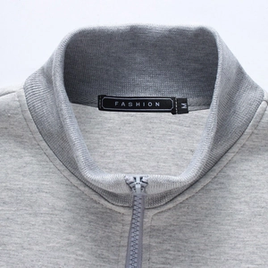 Close-up of a men's gray slim fit zip-up sports hoodie with ribbed collar and texture