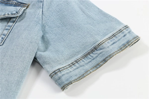 Detail of light blue washed denim sleeve cuff and pocket with yellow double stitching