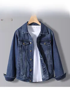 Close-up of dark blue denim jacket with classic collar and chest pockets hanging on wall