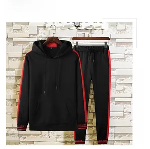 Détail du sweat à capuche noir et du pantalon avec bandes latérales rouges