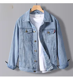 Detail of light blue denim jacket featuring dual flap pockets and metallic buttons