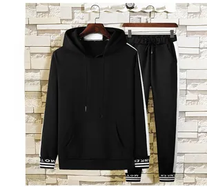 Détail de l'ensemble sweat à capuche et pantalon noir avec bandes blanches sur les côtés