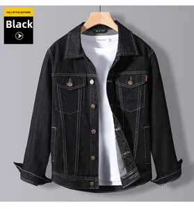 Detail of black denim jacket with contrast white stitching and buttoned chest pockets
