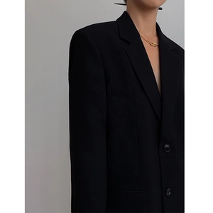 Detailed close-up of a black blazer featuring classic notch lapels and textured fabric
