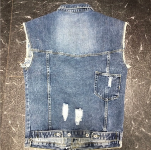 Detailansicht der Rückseite einer Jeansweste mit Distressed-Effekt und Fransenrand