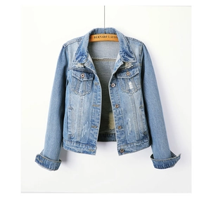 Detail of light blue distressed denim jacket with ripped accents and chest pockets