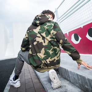 Outdoor shot of men's oversized street style hoodie featuring jungle camouflage pattern