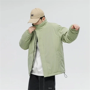 Detail of sage green puffer jacket featuring a high collar and adjustable drawstring hem