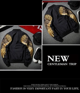 Detailed golden wings embroidery on back of black bomber jacket for streetwear style