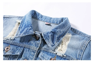 Detailed view of light blue denim jacket with distressed textures and metal buttons