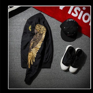 Detailed golden wing embroidery on the sleeve of a black MA-1 bomber jacket