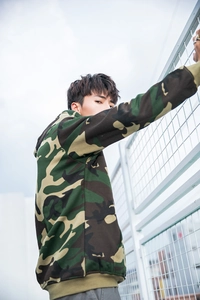 Outdoor low-angle shot of jungle camo hoodie with ribbed cuffs and hem on male model