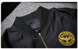 Detail of black flight jacket featuring gold zipper and circular eagle embroidery badge