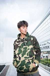 Detail of street style camouflage hoodie featuring ribbed cuffs and a front kangaroo pocket