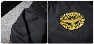 Detail of gold eagle embroidery on black MA-1 flight jacket showing fine stitching craftsmanship