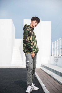 Street style view of woodland camo hoodie with multi-pocket grey cargo pants and white sneakers