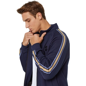 Détail de la veste de sport bleu marine avec bandes contrastées et logo sur la poitrine