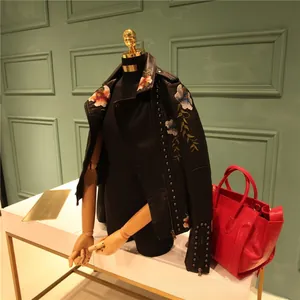 Detail of floral embroidery and silver metal studs on black PU motorcycle jacket