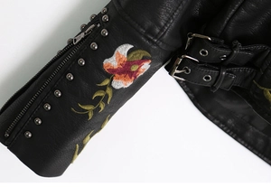Detailed embroidery with vibrant flowers and metallic studs on black PU jacket sleeve