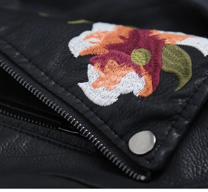 Close-up of floral embroidery detail with silver metallic studs on black PU leather jacket