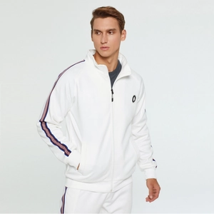 Détail d'une veste de sport blanche avec col montant et bandes latérales rouges et bleues