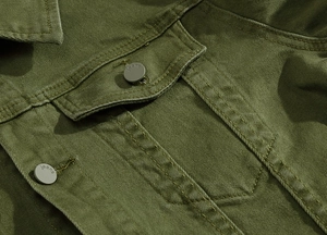 Dettaglio giacca di jeans verde oliva con tessuto strutturato e bottone jeans opaco