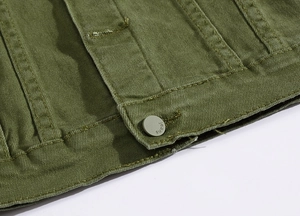 Dettaglio della giacca di jeans verde oliva con tessuto strutturato e bottone inciso